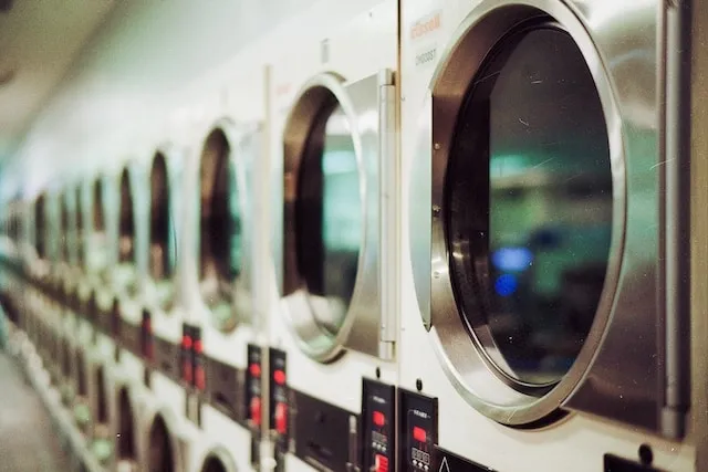 Row of commercial washing machines for how to wash polyester tablecloths